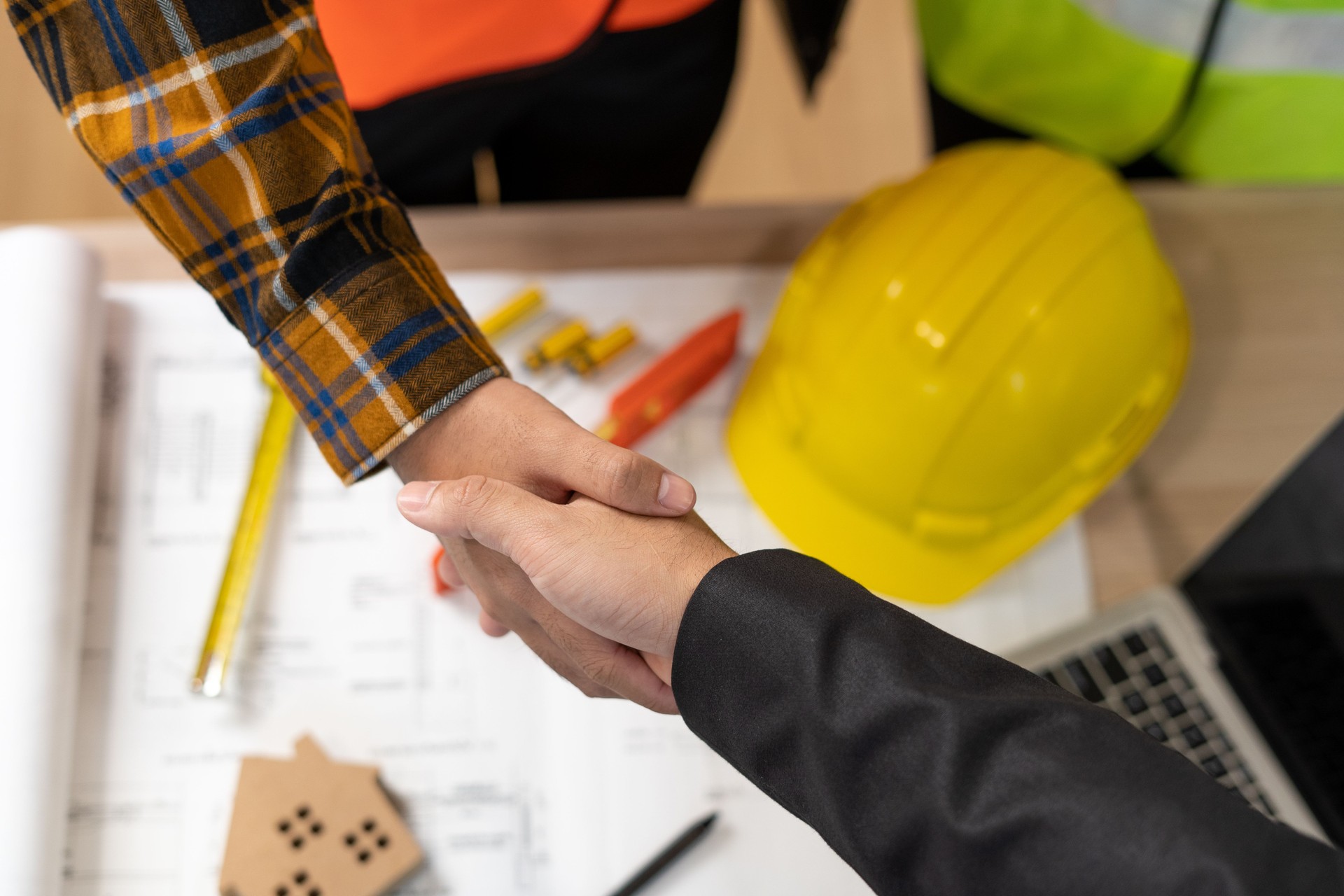 Customer shakes hands with construction team leader. Business agrees to sign a home builder after engineer shows model Building project. Mortgage, rent, buy, sell, purchase,move,Selling home.